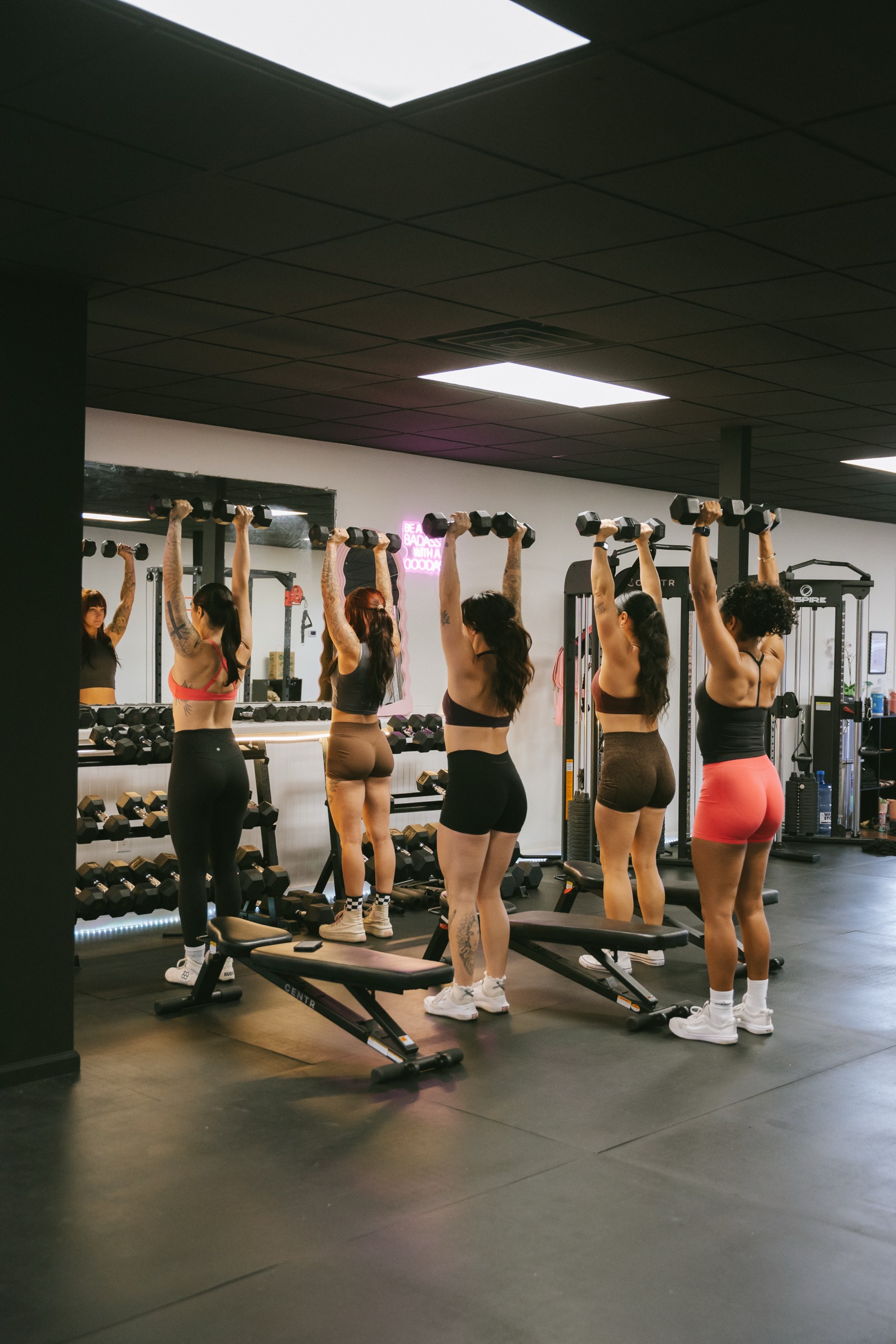 Women training together at Lift Studio Maui — overhead dumbbell press